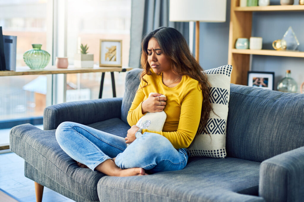  A young woman suffering from stomach cramps at home