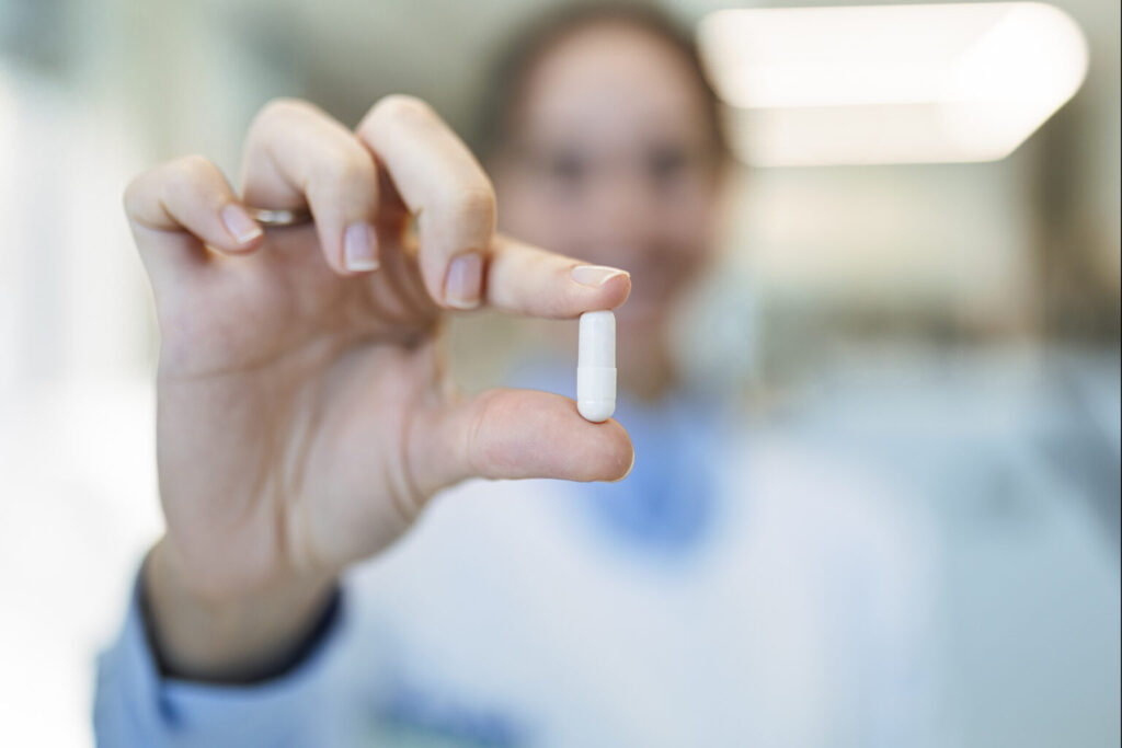 Medicine doctor holding a capsule pill in hand in laboratory